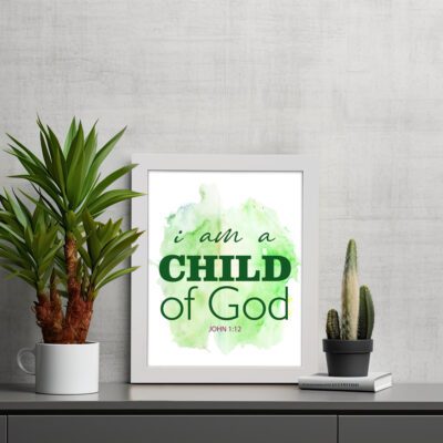 I Am A Child Of God wall art in elegant fonts with a green and black color scheme on a soft green watercolor background. displayed on the table in a white frame