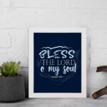 Infidu wall art featuring Bless The Lord O My Soul Psalm 103:1 in gold and white text on a dark blue background with decorative leaves. displayed on the wall in a white frame