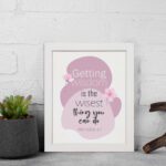 Christian wall art featuring the quote Getting Wisdom Is The Wisest Thing You Can Do from Proverbs 4:7, with pink flowers and soft colors. displayed on the wall in a white frame