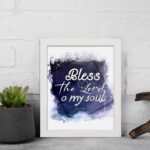 Bless The Lord O My Soul Psalm 103:1 Christian wall art with white text on a deep blue watercolor background. displayed on the wall in a white frame