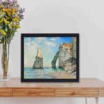 Vintage art print of Claude Monet's "The Cliffs at Étretat" (1885),displayed on a table with black frame