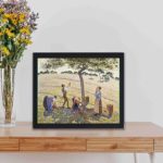 This vintage Pissarro "Apple Harvest" print,displayed on a table with black frame.