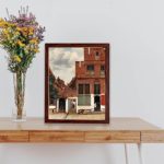 This stunning vintage art print of "The Little Street" by Johannes Vermeer,displayed on the table