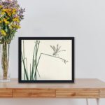 Beauty of nature with this vintage dragonfly art print by Kono Bairei,displayed on a table