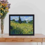 Enchanting beauty of Van Gogh's "Green Wheat Field with Cypress" with this vintage art print,displayed on a table