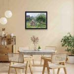 This vintage art print of "Apple Trees in Eragny" by Camille Pissarro,displayed on the wall with black frame.