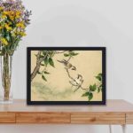 The playful charm of gossiping sparrows in this exquisite vintage art print,displayed on a table with black frame