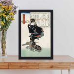 Vintage "Ichi" Art Print. Elegant Japanese woman, classic ukiyo-e style, black frame is placed on a table