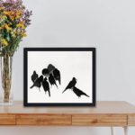 This vintage print showcases the enchanting beauty of Japanese crows.displayed on a table with black frame