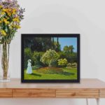 Monet's "Lady in the Garden". This vintage art print is a stunning reproduction displayed on a table with black frame