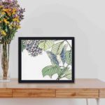 beauty and tranquility of nature with this stunning vintage art print of a moth and plant by Morimoto Toko,displayed on a table