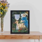 This vintage art print of Eacute;douard Manet's "Laundry (Le Linge)" painting.displayed on a table with black frame