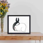 Discover the playful charm of Black and White Rabbits in this vintage art print by Kono Bairei,placed on the wall