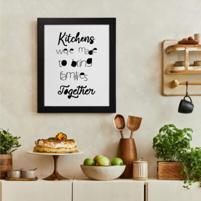 Kitchens were made to bring families together black text on a white background with small utensil illustrations, ideal for kitchen wall decor. There is a vegetable table, and above it, there is wall art.