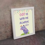 Colorful wall art featuring a cartoon elephant and the text 'God Is With Me Always' inspired by Matthew 28:20. displayed on the wall in a white frame