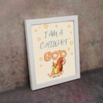 Wall art featuring a cartoon squirrel and the phrase I Am A Child Of God, inspired by John 1:12, on a light yellow background. displayed on the wall in a white frame