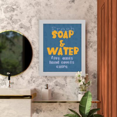 Infidu Fresh Soap & Water Five Cents Hand Towels Extra Bathroom Wall Art with deep blue background and bold yellow and white text. hung on the wall in the bathroom a white frame