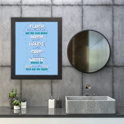 Flush the toilet bathroom wall art with soft sky-blue background, white and navy blue text reading "Flush the toilet, put the seat down. hung on the wall in the bathroom a black frame