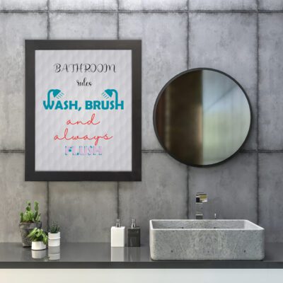 Bathroom Rules Wall Art with "Wash, Brush, and Always Flush" in teal, red, and gray fonts, light gray backgrounds, and handwashing icons. hung on the wall in the bathroom a black frame