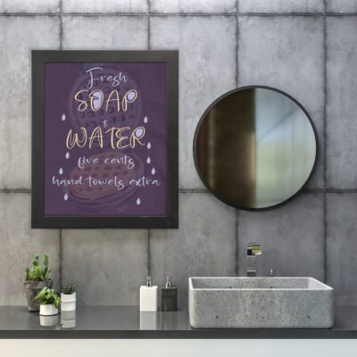 Infidu Fresh Soap & Water Bathroom Wall Art with purple background and white and gold lettering. hung on the wall in the bathroom a black frame