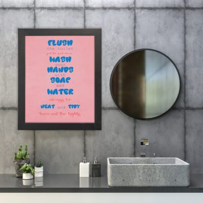 Infidu bathroom wall art with text "Flush the toilet, put the seat down, wash your hands with soap and water" on a light pink background. hung on the wall in the bathroom a black frame