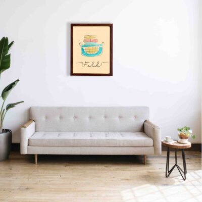 Laundry wall art with beige background, "Fold" in cursive, and a stack of folded clothes in a blue basket. a sofa below the wall art.