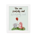 Cute wall art featuring an elephant and dinosaur with the verse You Are Fearfully and Wonderfully Made from Psalm 139:14. hung on the wall in a white frame