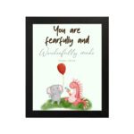 Cute wall art featuring an elephant and dinosaur with the verse You Are Fearfully and Wonderfully Made from Psalm 139:14. hung on the wall in a black frame