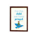 For This Child, We Have Prayed 1 Samuel 1:27 Bible Verse Wall Art with a child on blue bird illustration hung on the wall in a brown frame