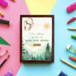 Watercolor wall art featuring a forest scene with the text I Have Called You By Name and You Are Mine from Isaiah 43:1. displayed on the wall in a brown frame in a colorful background