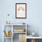 Cheerful rainbow wall art with the text Rainbows Are Your Promises in colorful letters, designed for kids' room decor. displayed on the wall in a brown frame