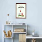 Cute wall art featuring an elephant and dinosaur with the verse You Are Fearfully and Wonderfully Made from Psalm 139:14. displayed on the wall in a brown frame