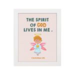 Infidu wall art featuring a cute angel with pink wings and a light blue dress, with the text The Spirit of God lives in me above. hung on the wall in a white frame