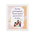 Wall art depicting Jesus as the Good Shepherd with children, featuring the verse I am the good shepherd from John 10:11. hung on the wall in a white frame