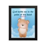 God Holds Me In The Palm Of His Hand Isaiah 49:16 Bible verse wall art for kids featuring a cartoon bear and fluffy clouds. hung on the wall in a black frame