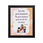 Wall art depicting Jesus as the Good Shepherd with children, featuring the verse I am the good shepherd from John 10:11. hung on the wall in a black frame