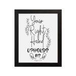 Wall art featuring the quote Your Right Hand Upholds Me from Psalm 63:8 in black text on a white background with floral designs hung on the wall in a black frame