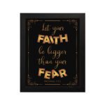 Infidu wall art with the text "Let your faith be bigger than your fear" in gold and bronze, with the Bible verse Hebrews 13:6 on a black background. hung on the wall in a black frame