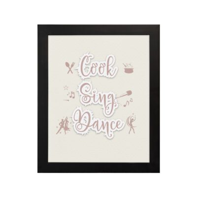 Cook Sing Dance kitchen wall art with pastel pink tones, a beige background, and musical notes. displayed on the wall in a black frame in a white background