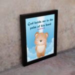 God Holds Me In The Palm Of His Hand Isaiah 49:16 Bible verse wall art for kids featuring a cartoon bear and fluffy clouds. displayed on the wall in a black frame