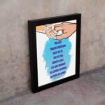 Wall art depicting two hands holding each other with the verse Let the little children come to me in blue text on a watercolor background. displayed on the wall in a black frame