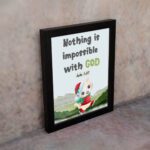 Wall art for kids featuring a happy cat in a Santa outfit holding a gift with the text Nothing is impossible with God. displayed on the wall in a black frame