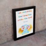 Colorful elephant wall art with the verse "Let everything that breathes praise the Lord!" for kids' room decor. displayed on the wall in a black frame