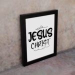 Jesus Christ wall art in black curly font on a white background, showcasing elegant Christian design. displayed on the wall in a black frame