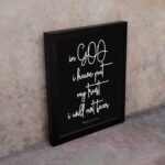 Christian wall art featuring Psalm 56:4 in bold white text on a black background. displayed on the wall in a black frame