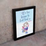 Wall art featuring a joyful bear in winter clothes holding a heart, with the verse We love because He first loved us from 1 John 4:19. displayed on the wall in a black frame