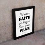 Let Your Faith Be Bigger Than Your Fear Hebrews 13:6 Christian Wall Art in black text on white background for home decor. displayed on the wall in a black frame