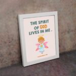 Infidu wall art featuring a cute angel with pink wings and a light blue dress, with the text The Spirit of God lives in me above. displayed on the wall in a white frame