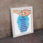 Wall art depicting two hands holding each other with the verse Let the little children come to me in blue text on a watercolor background. displayed on the wall in a white frame