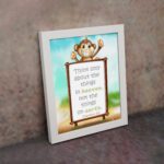 Wall art featuring a happy monkey holding a sign with the verse 'Think only about the things in heaven' from Colossians 3:2. displayed on the wall in a white frame